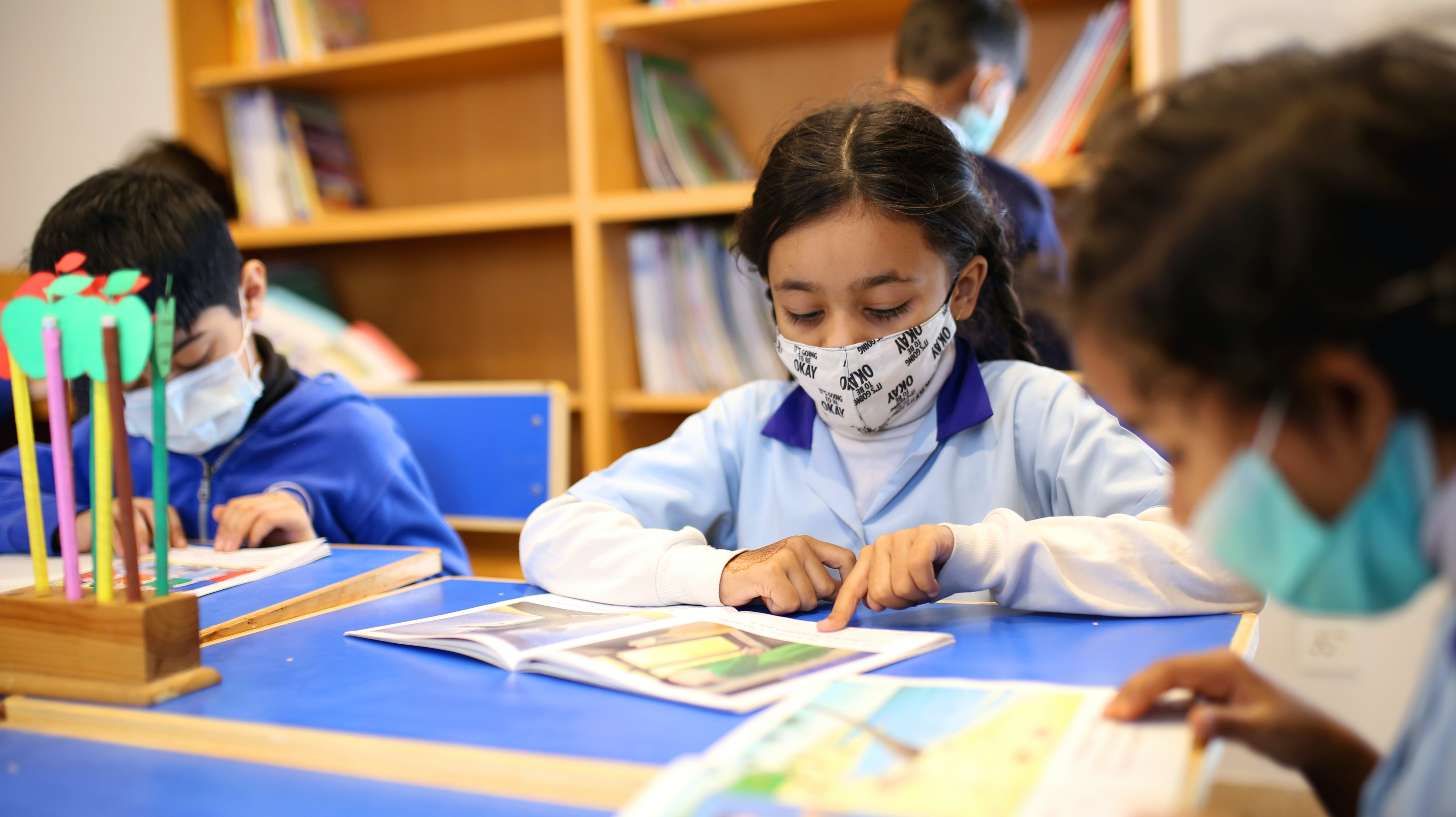 Children reading at school while wearing masks